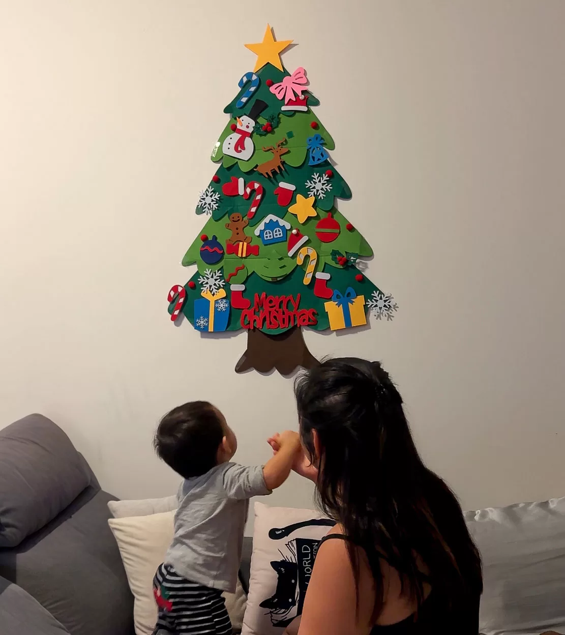 baby and mom looking up at baby-friendly felt christmas tree