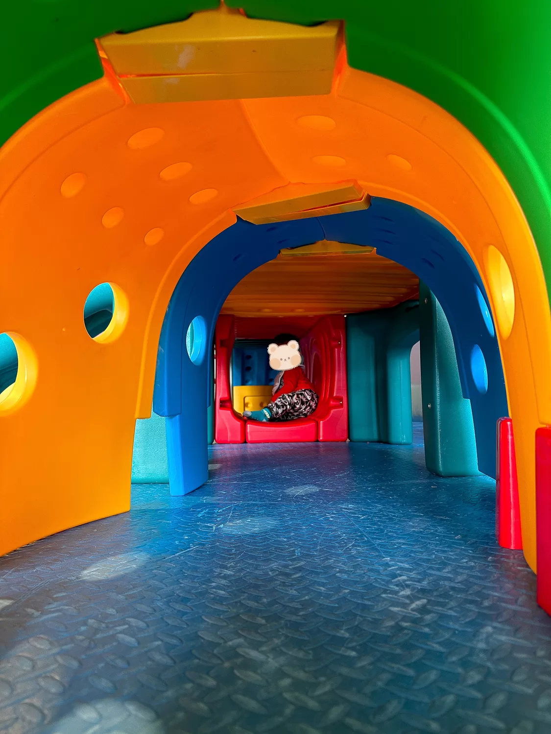 Toddler crawling in a playground tunnel